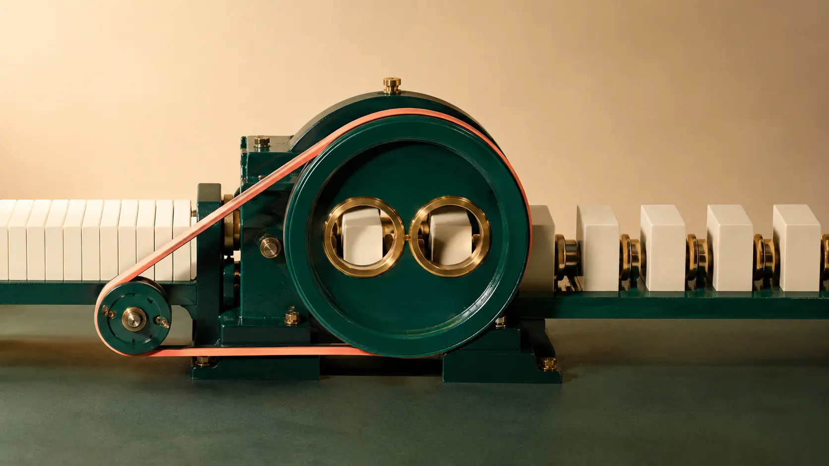 A petrol-green margin machine with twin apertures, dense cream blocks entering, and spaced blocks leaving